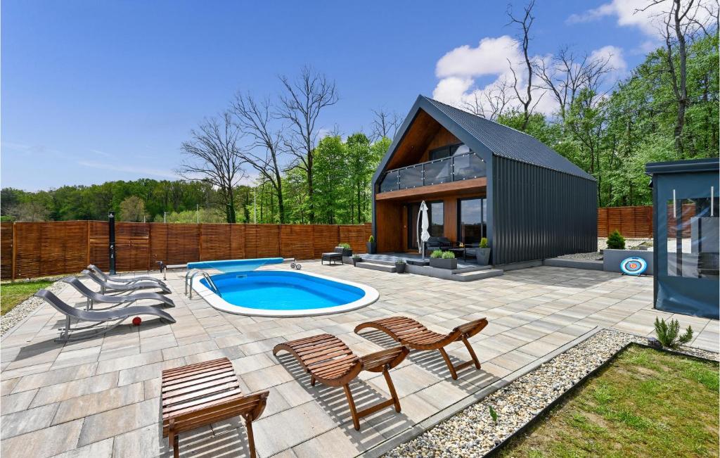 een achtertuin met een zwembad en stoelen en een huis bij Lovely Home In Ferdinandovac With Jacuzzi in Ferdinandovac