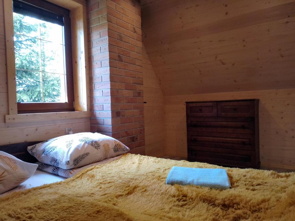 a bedroom with a bed in a room with a window at Cyrwony Domek in Poronin