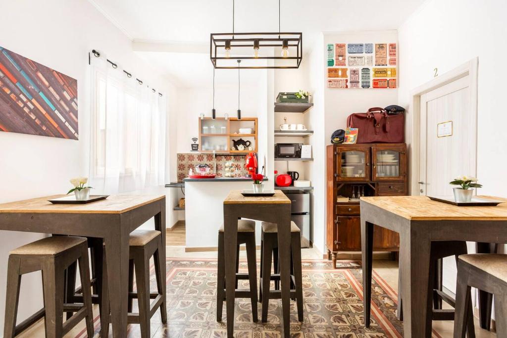 una cocina con mesas y taburetes de madera en Binario 91 Rooms, en Palermo