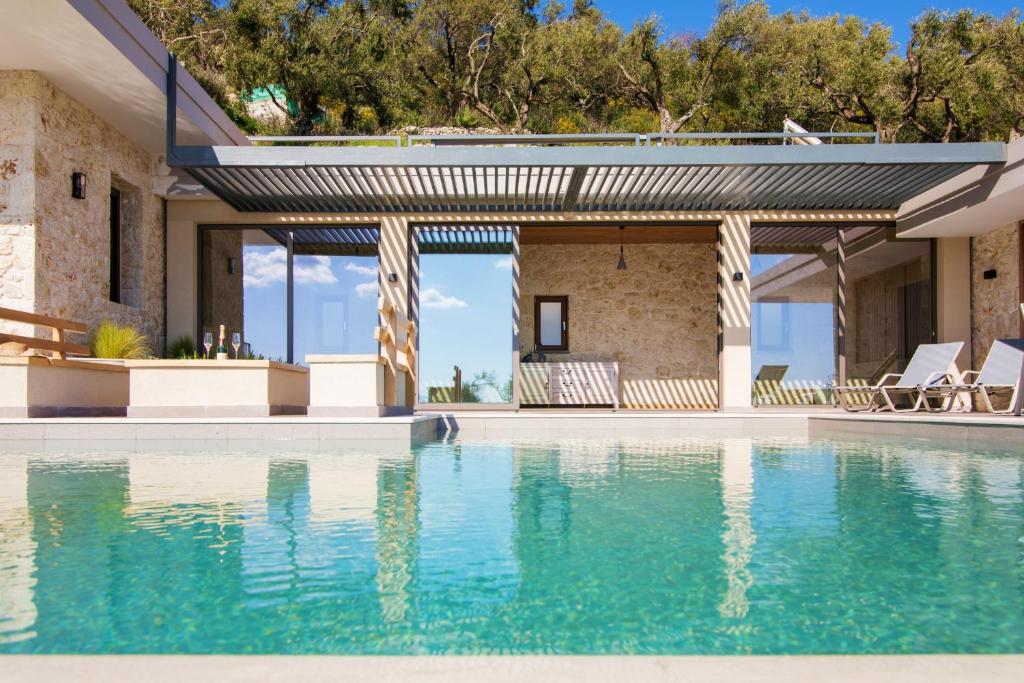 a house with a swimming pool with a patio at Villa Ble in Katávolos