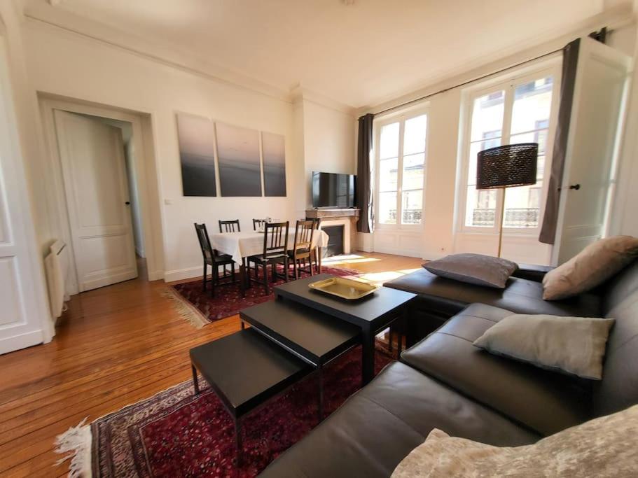 un salon avec un canapé et une table dans l'établissement Appartement lumineux Art-déco centre-ville parking, à Bordeaux