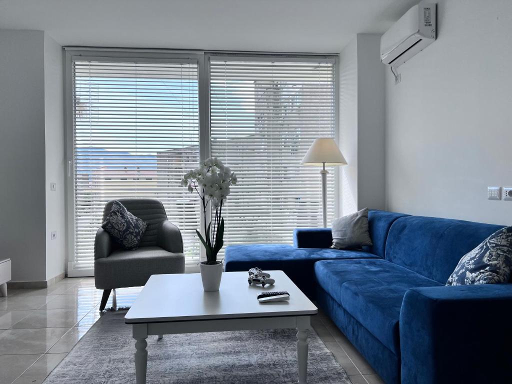 a living room with a blue couch and a table at White Luxury in Shkodër