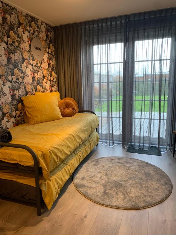 a bedroom with a bed and a large window at B&B slapen in de veenhoop in De Veenhoop