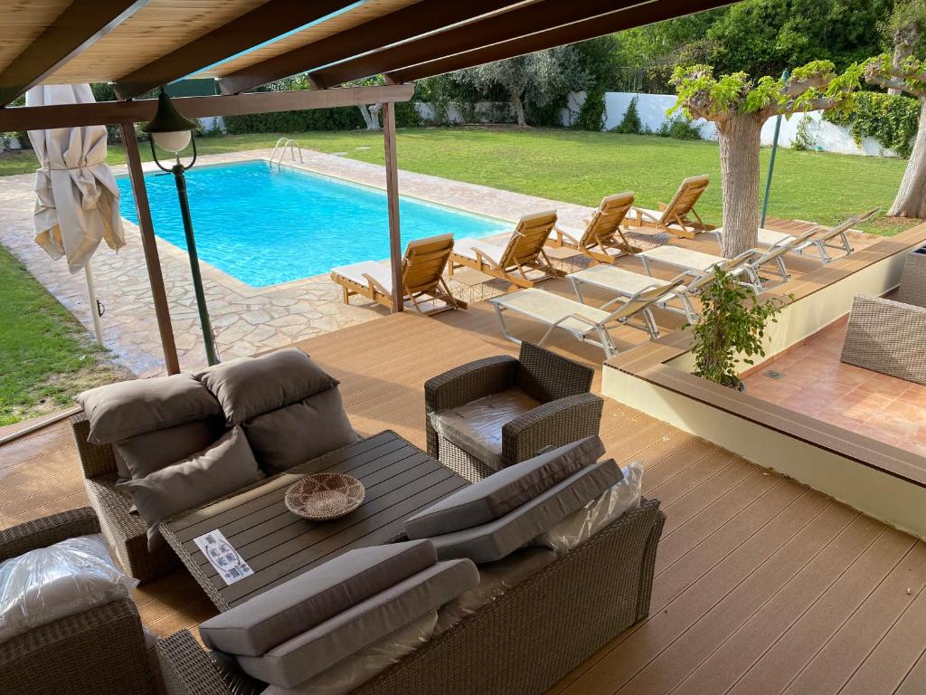 un patio con sofás y una piscina en Relaxing Villa with Swimming Pool and Garden, en Áyios Yeóryios