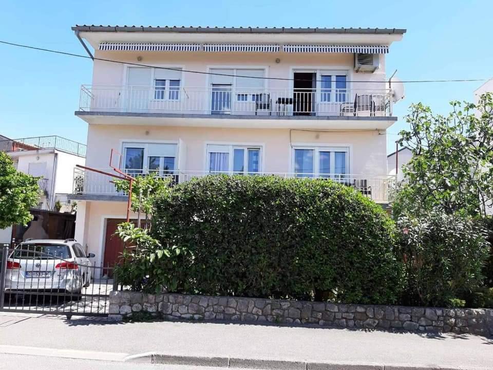 a white building with a balcony on top of it at Apartmani Ernesta in Selce