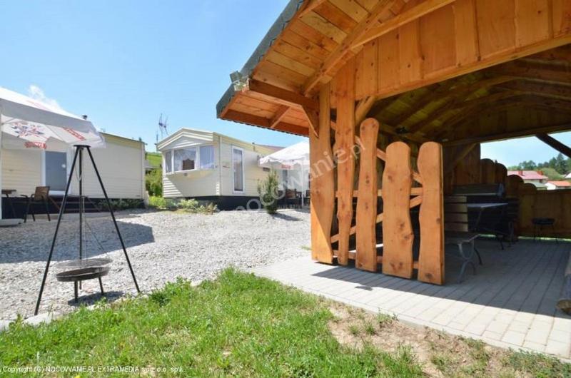 einem Holzpavillon mit einer Bank im Hof in der Unterkunft Plaża Pieniny - domki holenderskie in Czorsztyn