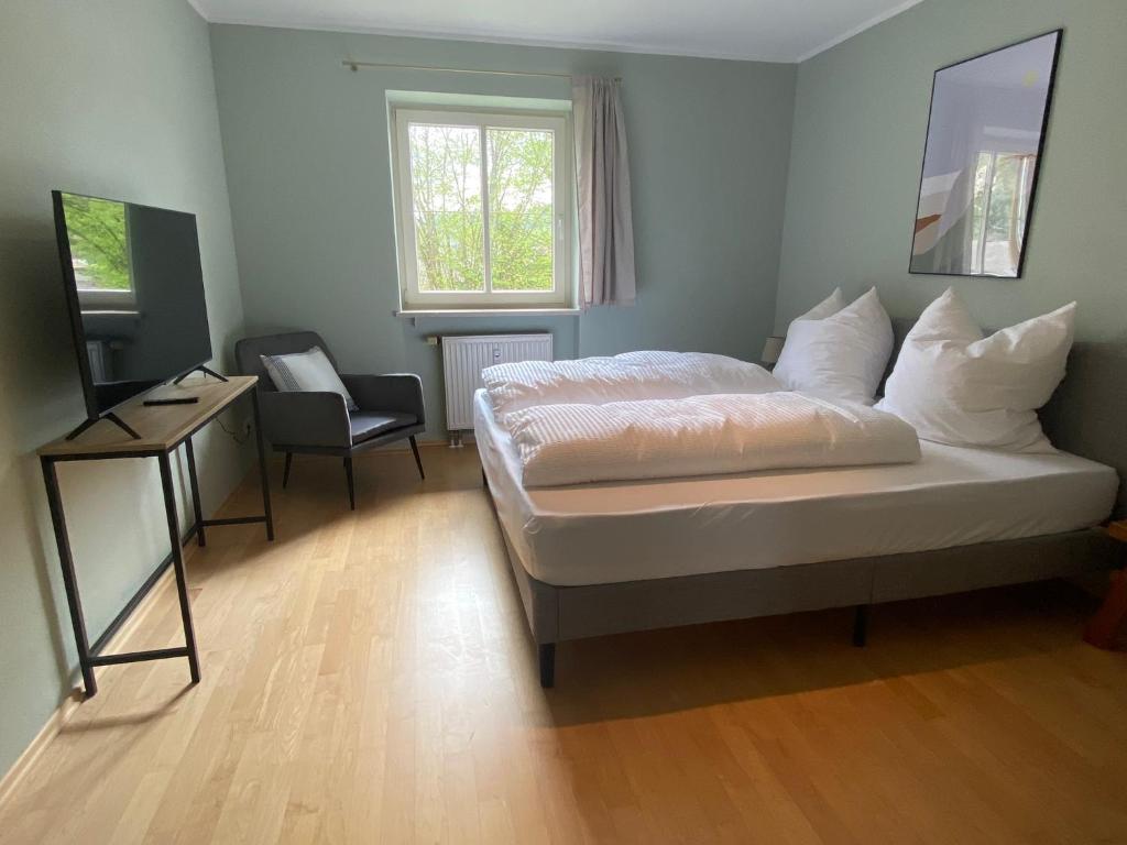 Schlafzimmer mit einem Bett, einem Schreibtisch und einem Stuhl in der Unterkunft Bayern Lodge Bergen in Bergen