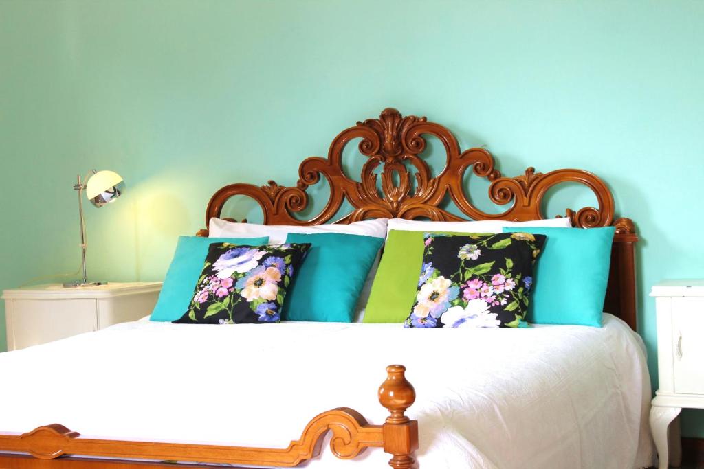 - un lit avec une tête de lit et des oreillers en bois dans l'établissement Il giardino dei fiori, à Mandello del Lario