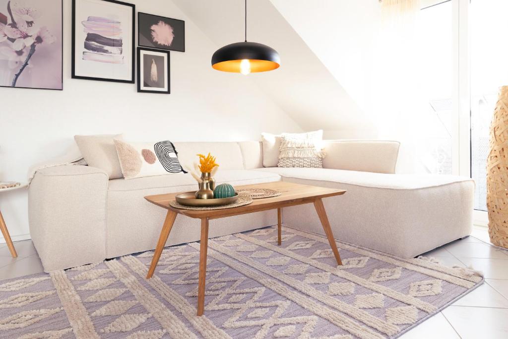een woonkamer met een witte bank en een tafel bij Sohana Lifestyle Apartments I Leilani's & Saskia's Home I Rust in Rust