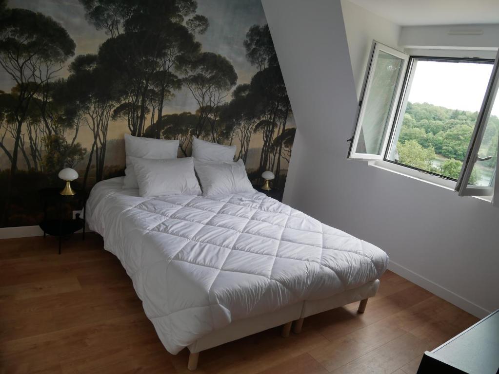 - une chambre avec un lit blanc orné d'une peinture murale dans l'établissement Villa Kerandraon, à Gouesnach