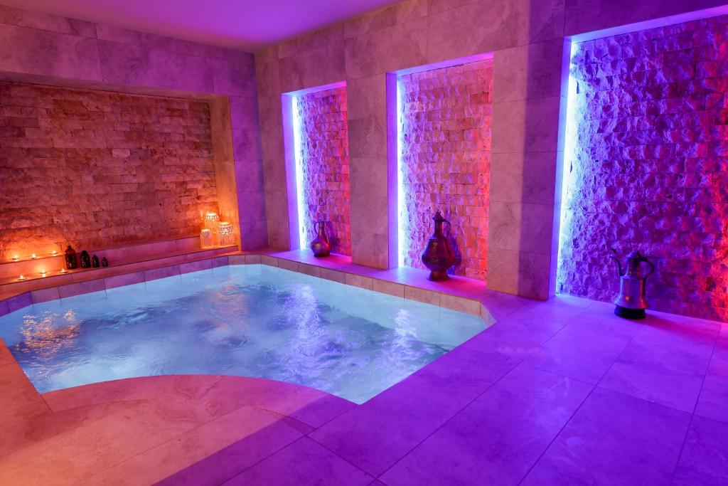 a hot tub in a room with purple lighting at Louis Cappadocia in Uçhisar