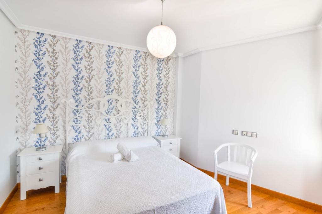 sypialnia z białym łóżkiem i krzesłem w obiekcie La LLamosa Beach&Nature w mieście Galizano