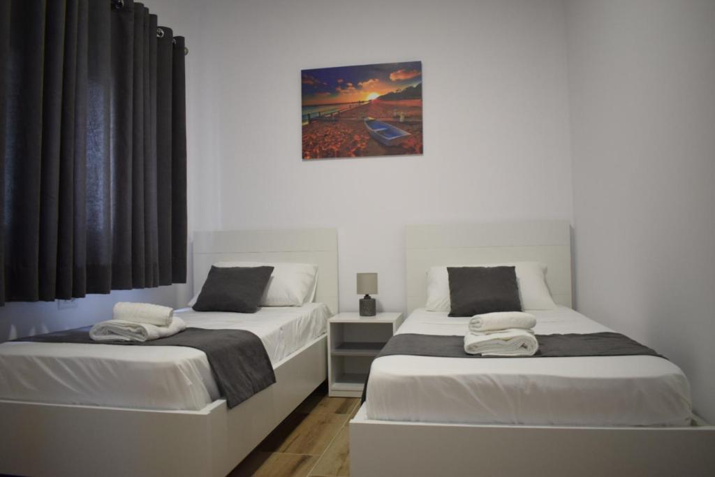 1 dormitorio con 2 camas y una foto en la pared en Sunset Cottage 1, en Ksamil