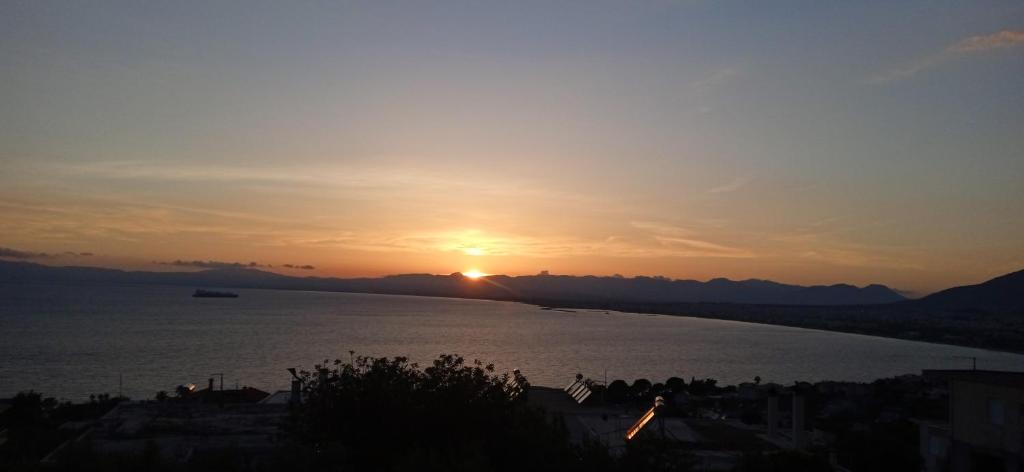 a sunset over a body of water with a city at Four Seasons Verga in Kalamata