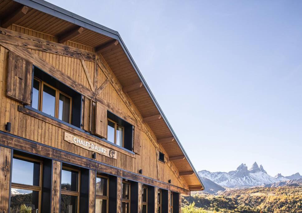 a wooden building with mountains in the background at Chalet d'Albiez in Albiez-Montrond
