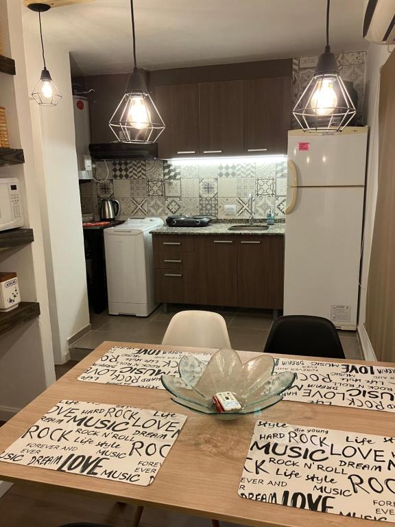 a kitchen with a wooden table and a white refrigerator at Depto 23 en Barrio Villa Belgrano excelente ubicación in Cordoba