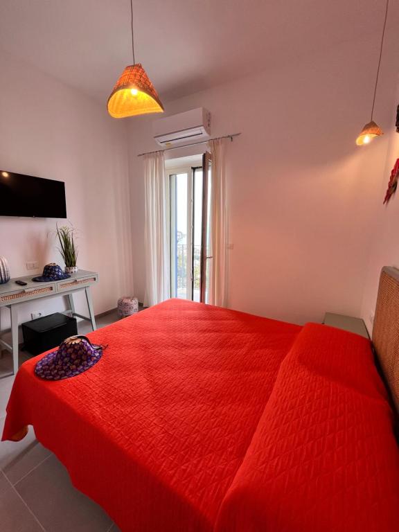 1 dormitorio con cama roja y escritorio en Thai Boutique rooms en Peschici