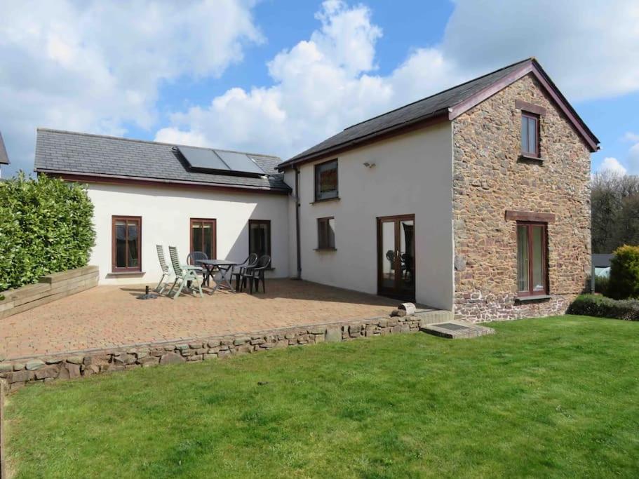 a detached house with a patio and lawn at Creedy Meadow Barn in Crediton