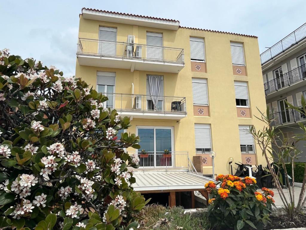a yellow apartment building with a balcony and flowers at Piccolo Hotel di Lavagna in Lavagna