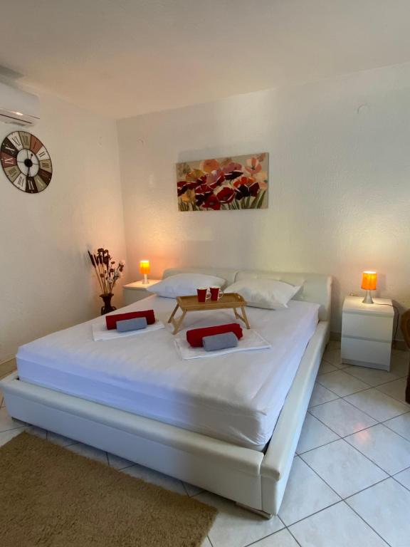 a bedroom with a large white bed with two lamps at Apartments and Rooms Pavla in Senj