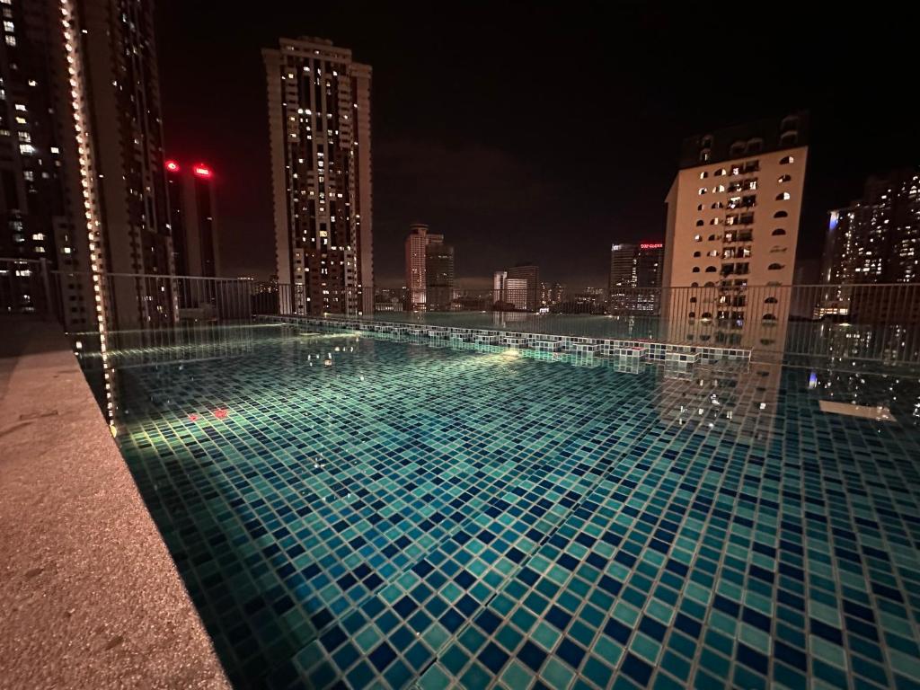 Chambers Suites KL في كوالالمبور: مسبح على سطح مبنى في الليل