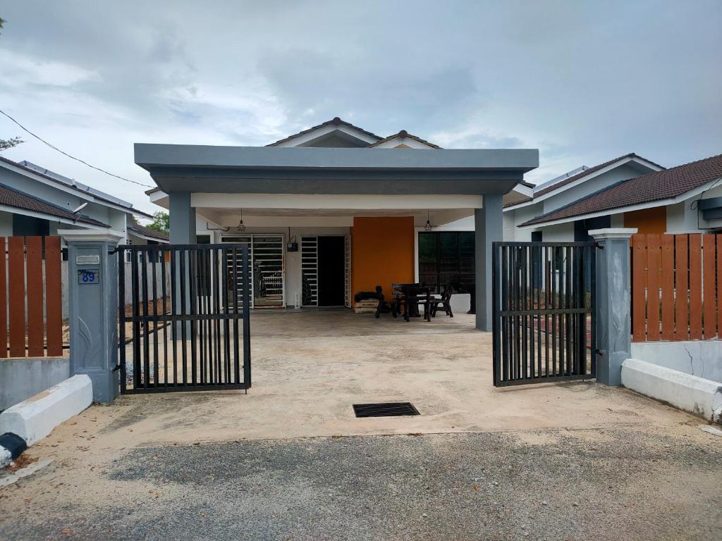 een huis met een hek ervoor bij Adam Homestay Besut in Kampung Raja