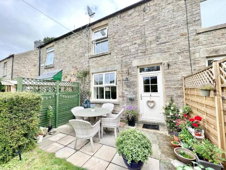a patio with a table and chairs in front of a building at Impressive 3 bed cottage by the river in Stanhope in Stanhope