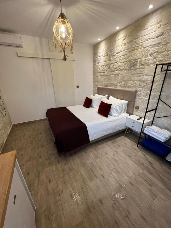 um quarto com uma cama grande e um lustre em CARA Creta Beach House em Kolymvari