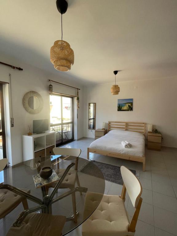洛里尼揚的住宿－Sol & Surf，一间卧室配有一张床和一张玻璃桌
