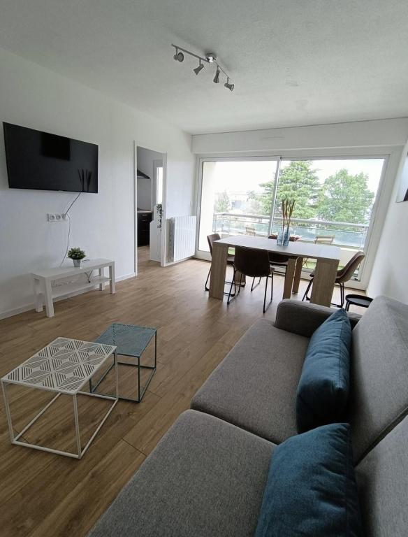 een woonkamer met een bank en een tafel bij Appartement sans vis à vis à 2 min de la rocade in Rennes