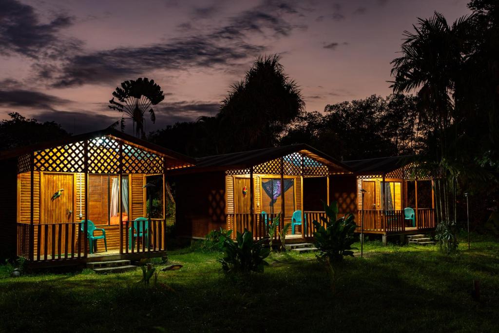 una fila de cabañas de madera en un patio por la noche en Oso de Osa Finca y Eco-Resort, en Sierpe