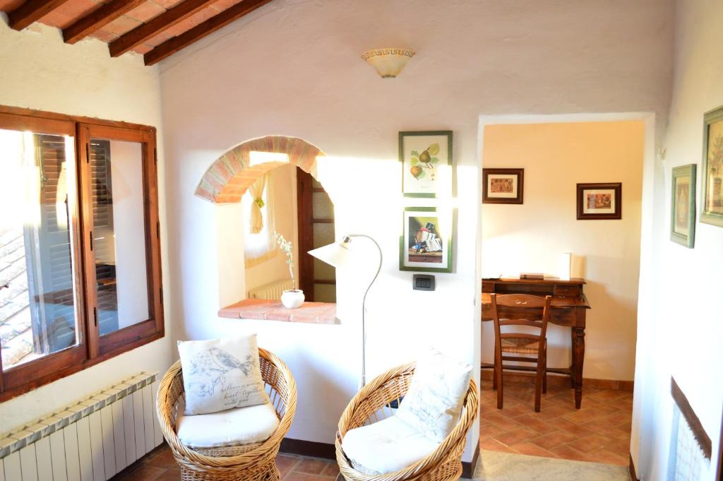 sala de estar con 2 sillas y espejo en Apartment with Little Arch, en Montepulciano