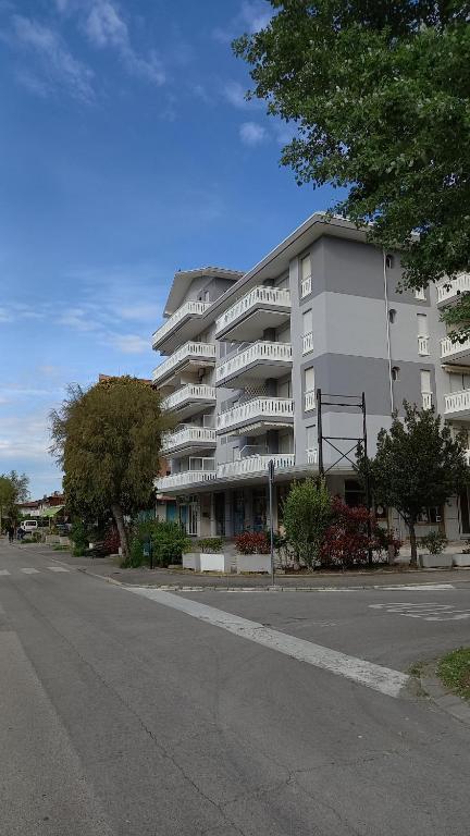 ein großes weißes Apartmenthaus an der Straßenseite in der Unterkunft Aria in Porto Santa Margherita