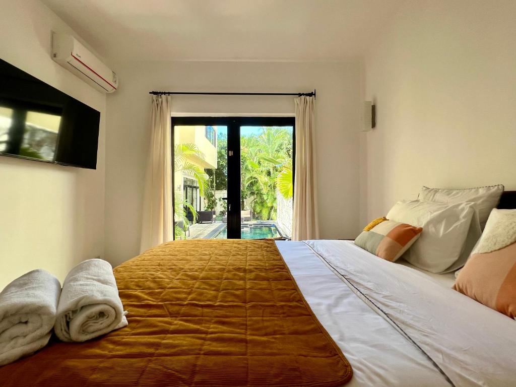 1 dormitorio con 1 cama grande y ventana grande en Villa Hacienda 4 en Cap Malheureux