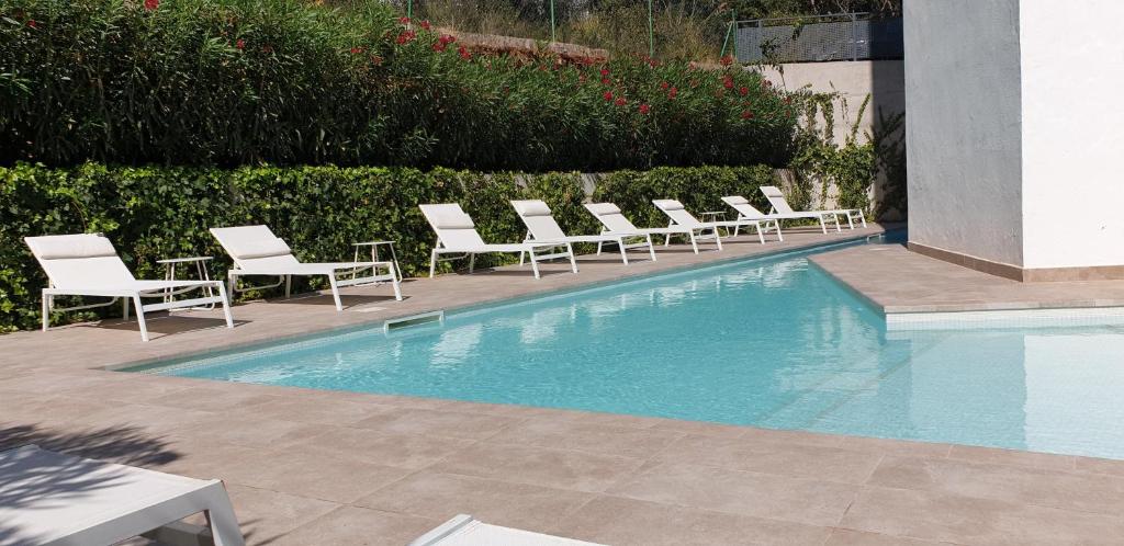 una fila de sillas sentadas junto a una piscina en Apartment Formentor with sea view, pool & terrace in Canyamel, en Canyamel