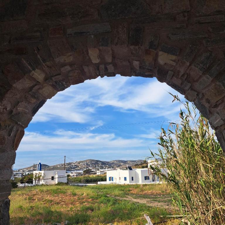 an arch in a stone bridge with a city in the background at stegio in Parasporos