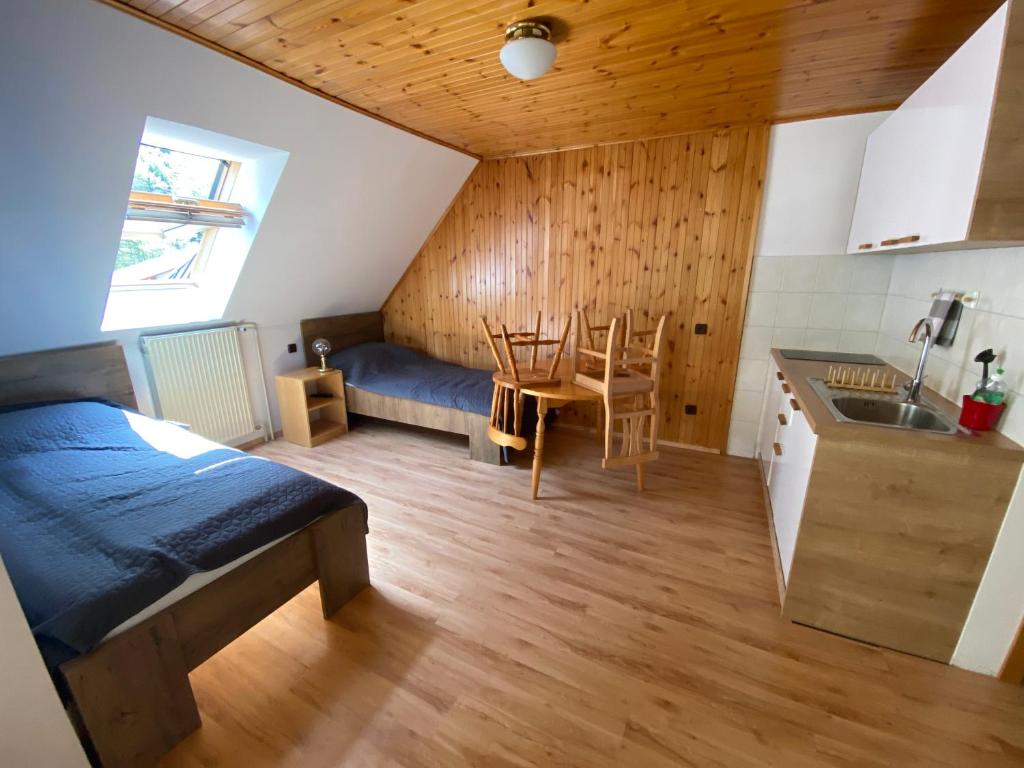 Habitación con cama, mesa y cocina. en Encijan Apartments, en Log pod Mangartom