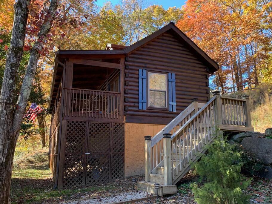 een blokhut met een trap naar een veranda bij Log Cabin Walkable to Lake Lure & Chimney Rock - Blue Skies in Lake Lure