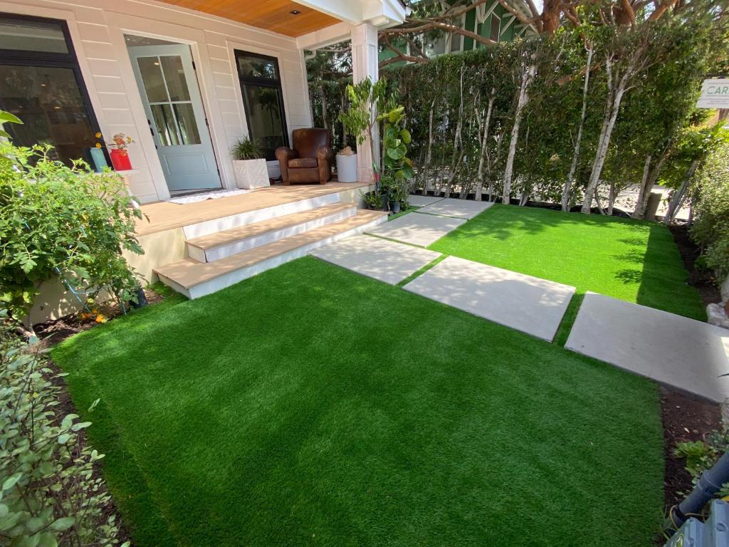 a yard with green grass and a house at Bright modern new coastal home with inspiring details in Santa Monica in Los Angeles