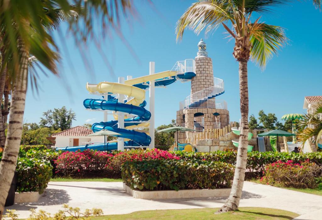 a water slide in a park with palm trees at Apartment in Dominicus in Bayahibe