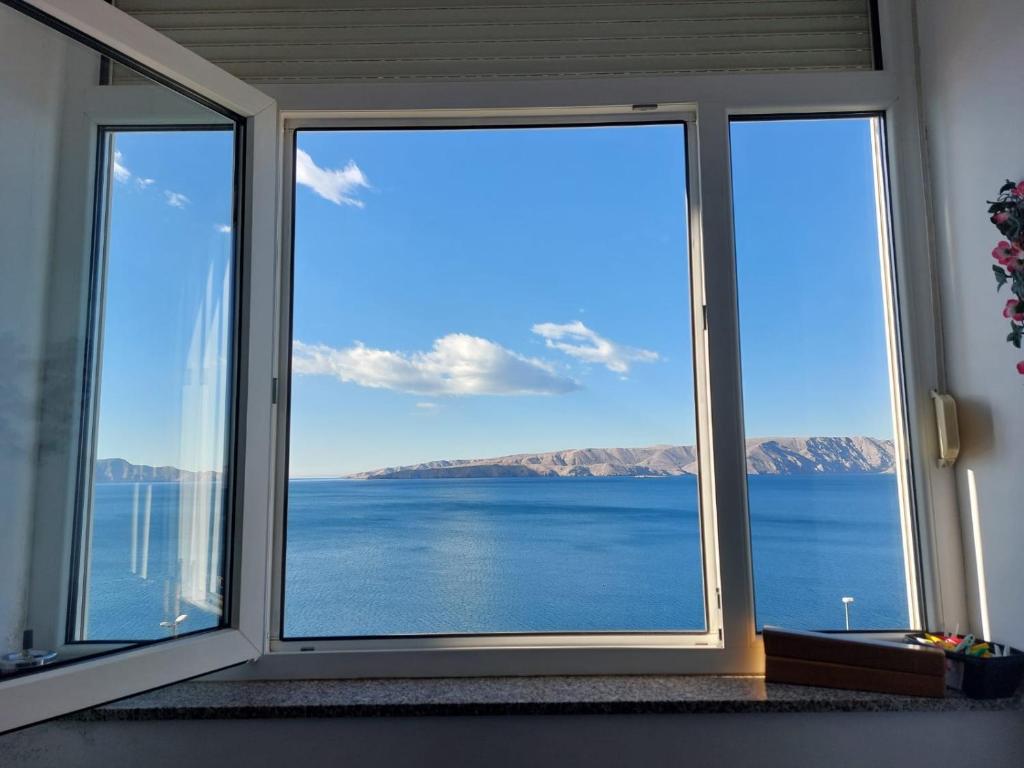 une fenêtre avec vue sur l'eau dans l'établissement Apartment Sunset, à Senj