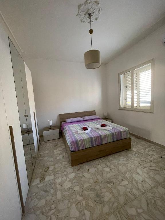 a bedroom with a bed and a chandelier at Spagna Apartament in Siracusa