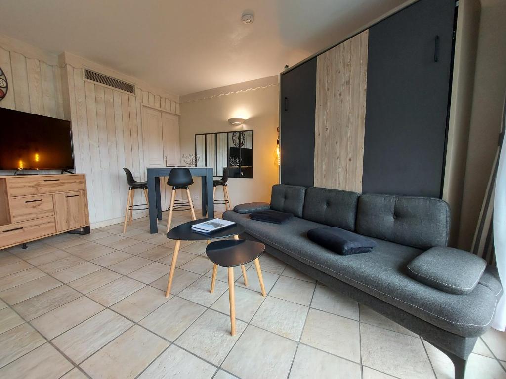 uma sala de estar com um sofá e uma mesa em Rare : au bord du lac d’Annecy, cosy appartement en rez de jardin avec terrasse privative em Duingt