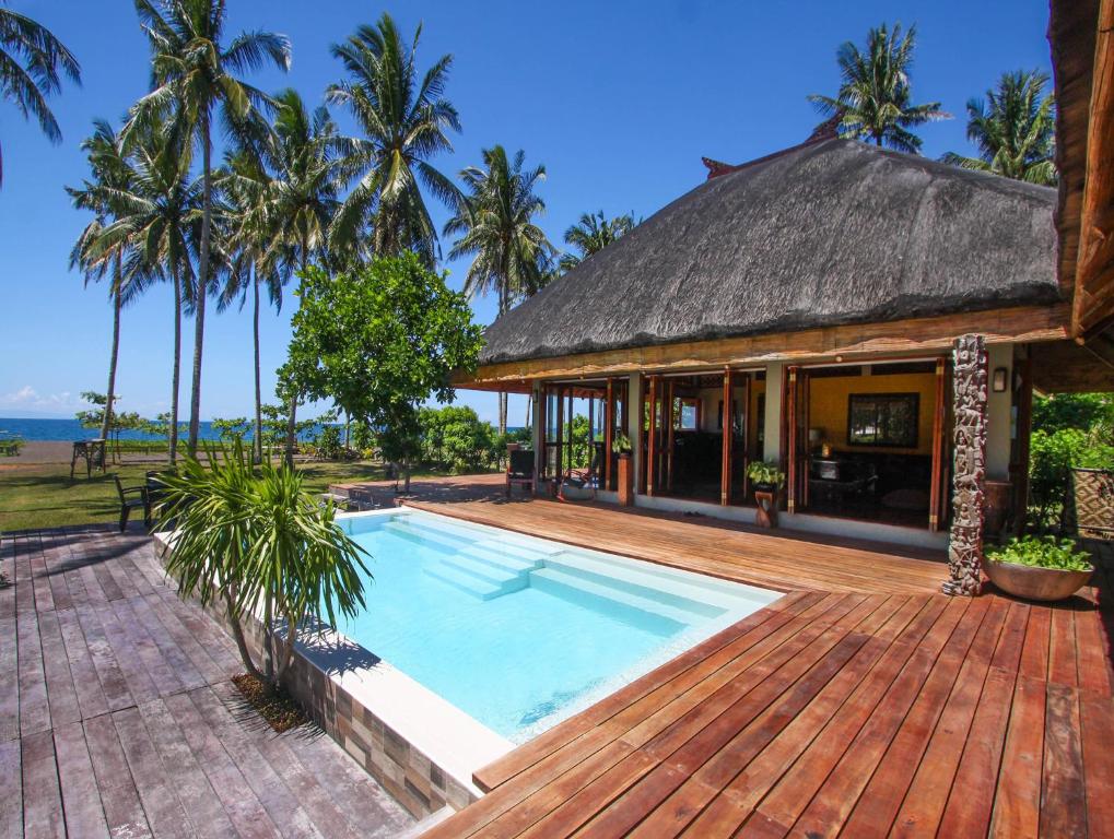 uma casa com uma piscina e um deque de madeira em Balai sa Baibai em Mambajao