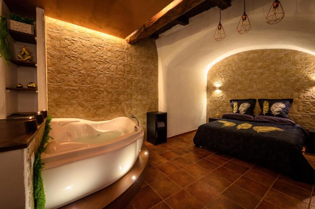 Schlafzimmer mit Badewanne und Bett in der Unterkunft Relais il Duomo con SPA privata in Sutri