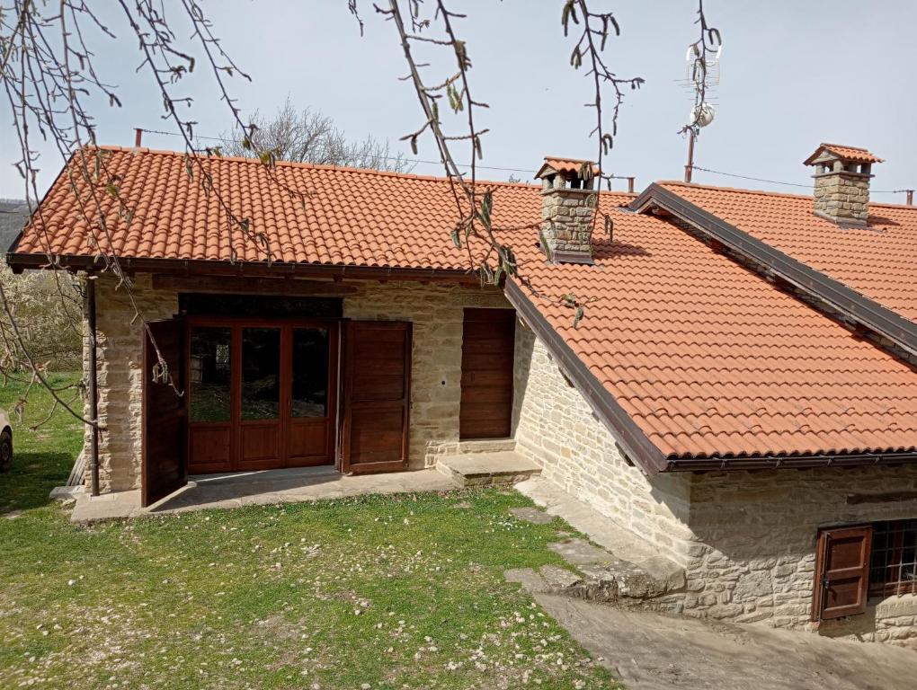 una casa con techo naranja y puerta en Rocca Corneta, en Palazzuolo sul Senio