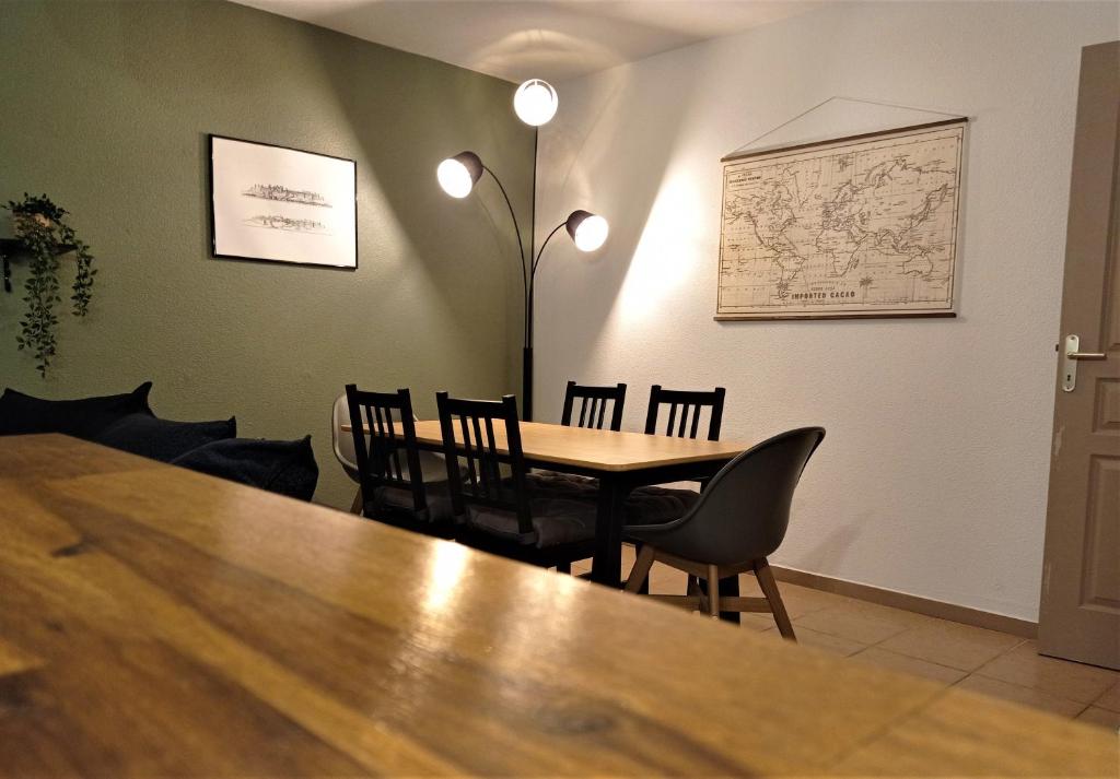 une salle à manger avec une table et des chaises ainsi qu'une carte murale dans l'établissement Appartement proche Cité médiévale et centre ville - Parking privé, à Carcassonne