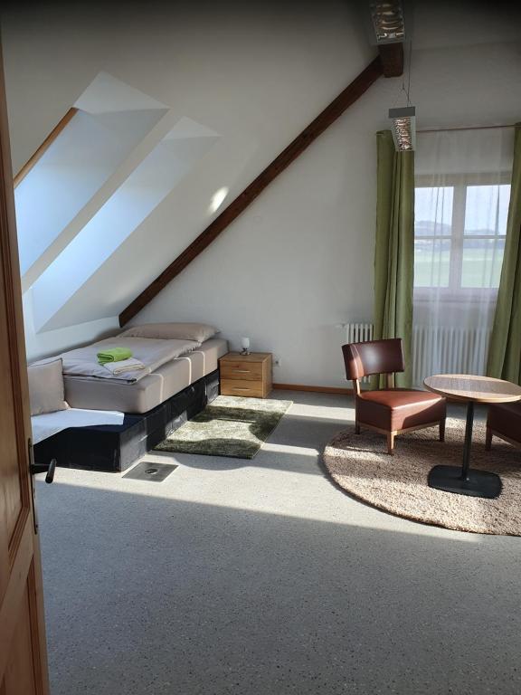 um quarto com uma cama, uma cadeira e uma mesa em Gutshof Seenland em Seekirchen am Wallersee