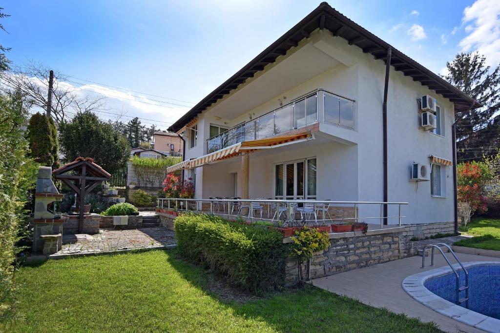 a house with a balcony and a yard at Villa Holiday in Balchik