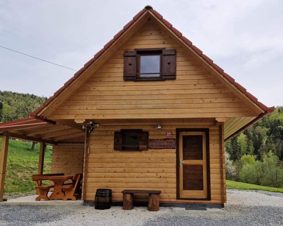 a log cabin with a window and a picnic table at Brunarica Jeršin in Cerkno